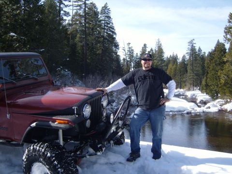 1985 Jeep CJ7 - Man poses with his 1985 Jeep CJ7 in a winter scene with snow and trees.