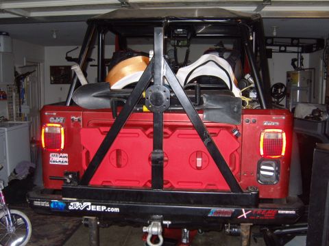 1985 Jeep CJ7 - This 1985 Jeep CJ7 is equipped with a rear tire carrier, dual jerry cans, and shovels, ready for adventure.