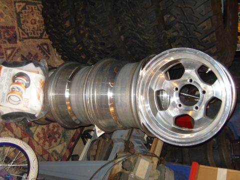1985 Jeep CJ7 - Several aluminum alloy wheels are stacked together with new bearing kits on the left.