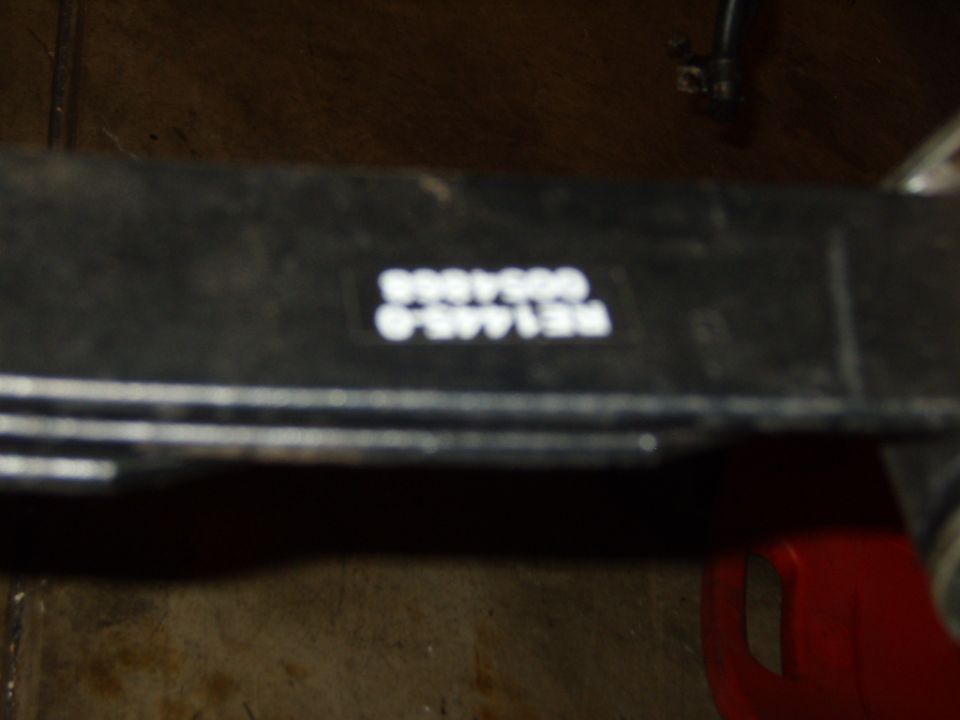 Black metal part with white text reading RE1445.0 0054868