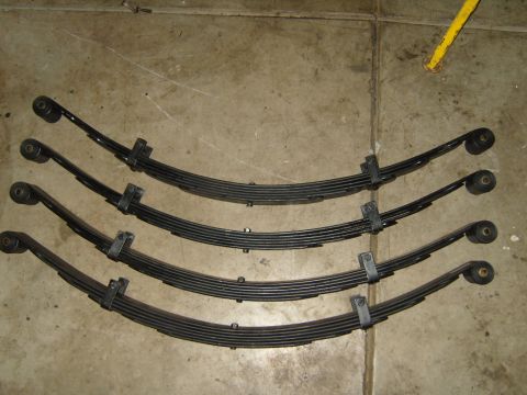 1985 Jeep CJ7 - Set of four leaf springs shown on a concrete surface, with a Supermotors.net watermark.
