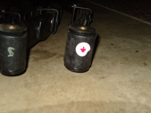 1985 Jeep CJ7 - These are leaf spring bushings, one of which has a Canadian maple leaf emblem on it.
