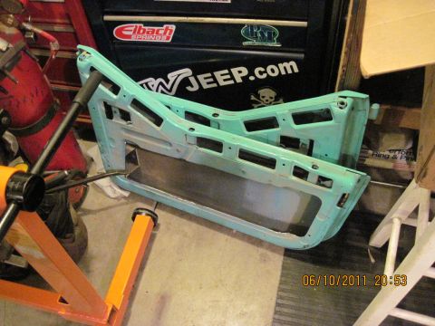 1985 Jeep CJ7 - Two disassembled teal Jeep doors are shown in a workshop setting.