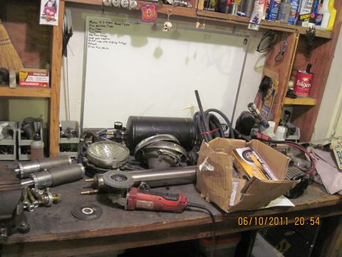 1985 Jeep CJ7 - Workbench filled with automotive parts and tools, suggesting ongoing vehicle maintenance or customization.