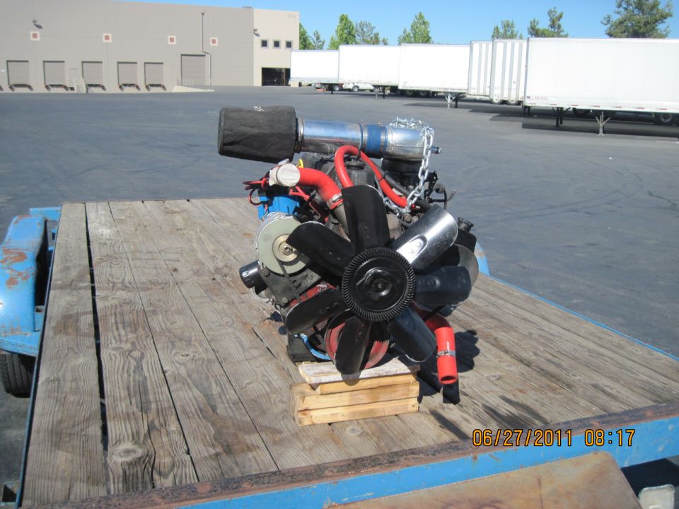 engine with air filter and fan on a wooden trailer bed