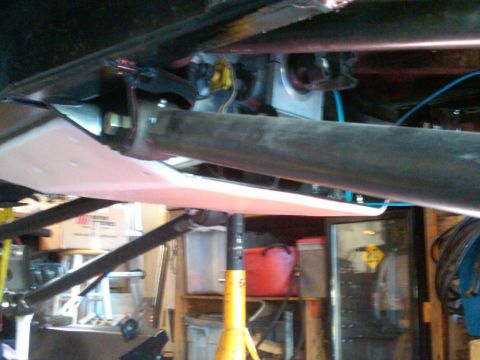 1985 Jeep CJ7 - Undercarriage view of a vehicle being worked on, showing suspension parts and a protective plate.