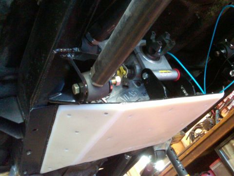 1985 Jeep CJ7 - Close-up view of the undercarriage, focusing on a skid plate and mechanical parts with visible 'ATLAS' branding.
