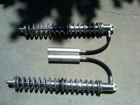 1985 Jeep CJ7 - Two aftermarket shock absorbers are shown, likely for an off-road vehicle. The "SUPERMOTORS.NET" watermark is visible.