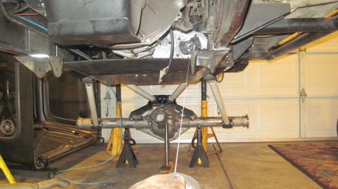 1985 Jeep CJ7 - The rear axle assembly of a vehicle is suspended on jack stands for maintenance or modification.