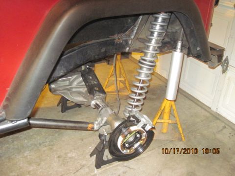 1985 Jeep CJ7 - The rear suspension and axle of a Jeep are being worked on, supported by jack stands.