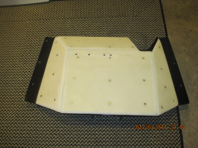 White plastic part with black trim on carpet