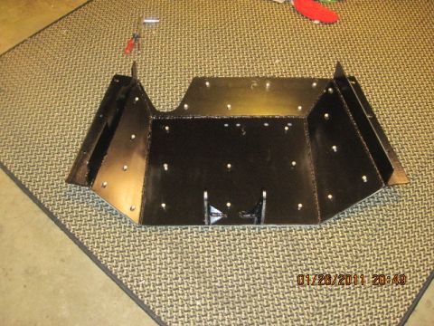 1985 Jeep CJ7 - A black metal skid plate is shown on a mat, with tools visible in the background.