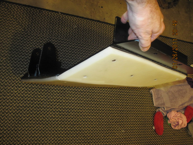 hand holding a skid plate with mounting brackets
