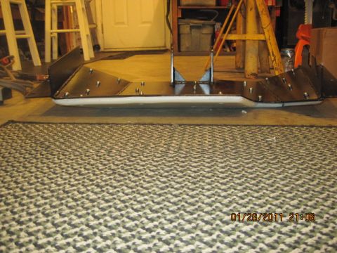 1985 Jeep CJ7 - A custom metal skid plate with white trim is shown in a garage setting.