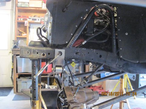 1985 Jeep CJ7 - Jeep frame and suspension components are visible, supported by jack stands in a workshop.