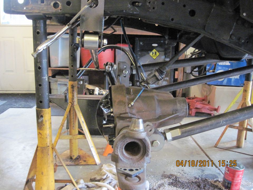 Jeep chassis and suspension parts on jack stands, with a differential visible
