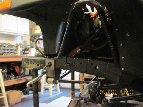 1985 Jeep CJ7 - Close-up of the frame and suspension of a 1985 Jeep CJ7 in a garage.