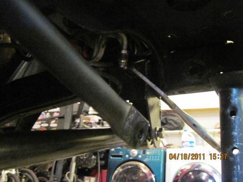1985 Jeep CJ7 - Close-up view of a vehicle's undercarriage components, showing mechanical linkages and structural elements.