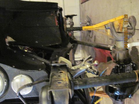1985 Jeep CJ7 - Close-up view of the front suspension and frame of a 1985 Jeep CJ7, showing repair or modification work in progress.