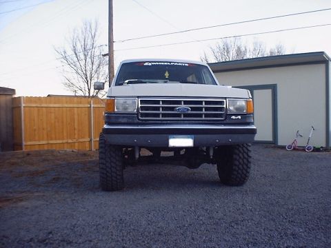 1988 Ford Bronco - Front view of a lifted 1988 Ford Bronco with large off-road tires.
