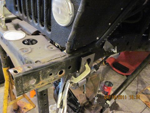 1985 Jeep CJ7 - The front frame section of a Jeep is shown with various tools and parts, indicating a repair or modification process.