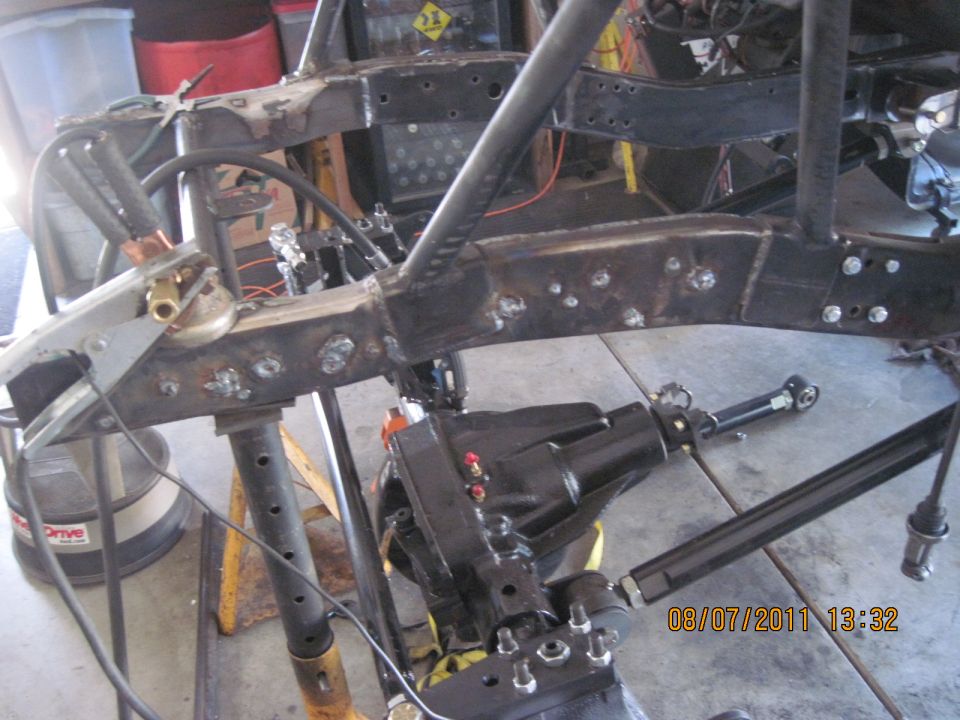 Jeep frame with differential and suspension parts, undergoing modification