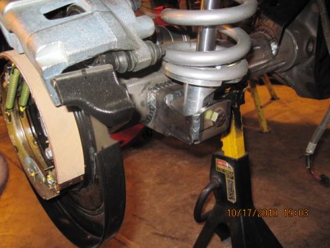 1985 Jeep CJ7 - Close-up view of a vehicle's rear axle assembly, including brake components and suspension, supported by a jack stand.