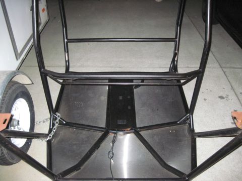 1985 Jeep CJ7 - Interior view of a custom roll cage, with a trailer hitch and wheel visible to the left.