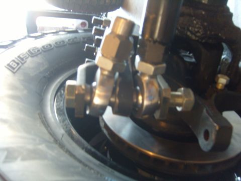 1985 Jeep CJ7 - Detail shot of suspension linkage and tire on a vehicle.