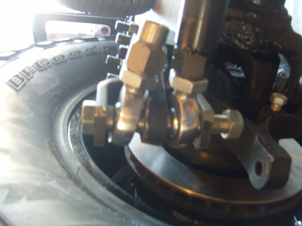 Close-up of vehicle suspension parts and tire sidewall with BFGoodrich text