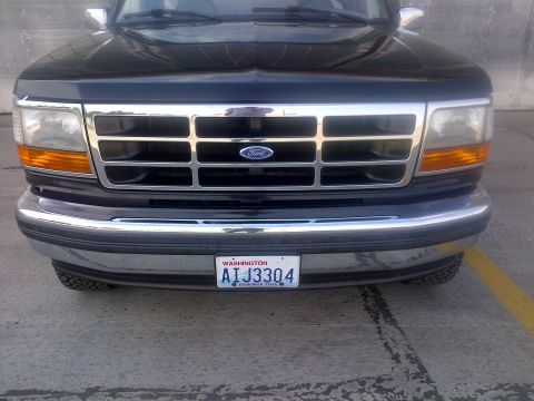 1994 Ford Bronco - Front view of a black Ford truck, a prominent chrome grille and a Washington state license plate.