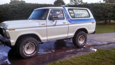 1979 Ford Bronco - This two-tone Ford Bronco is shown from the side, parked on a driveway with water and soap residue.