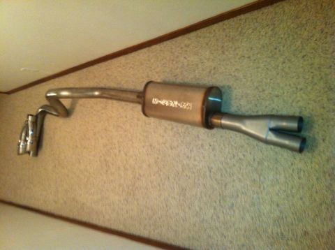 1982 Ford Bronco - An exhaust system, likely for a vehicle, is displayed against a textured wall.