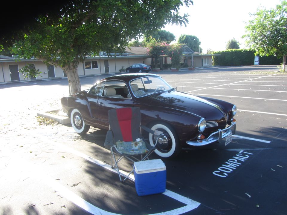 Maroon coupe with whitewall tires parked in a compact spot