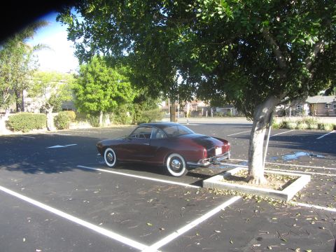 1968 Ford Mustang - A classic coupe with whitewall tires is parked in a lot under a tree.