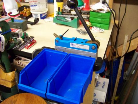 1995 Mercury Grand Marquis - A cluttered workbench displays various tools and supplies for ammunition reloading.