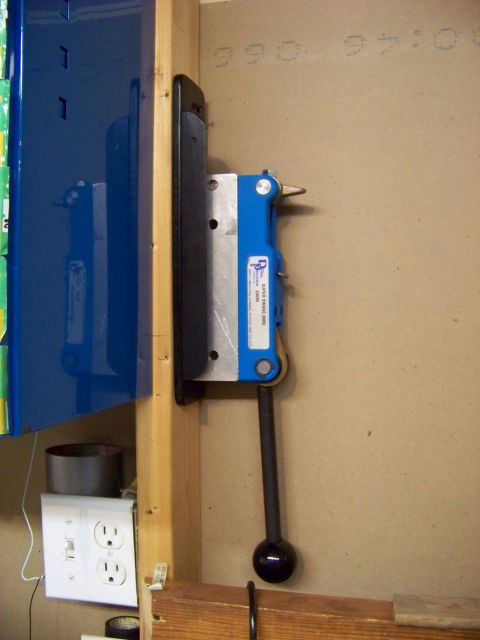 1995 Mercury Grand Marquis - A blue metal part with a handle, possibly a tool, is mounted on a wooden support.