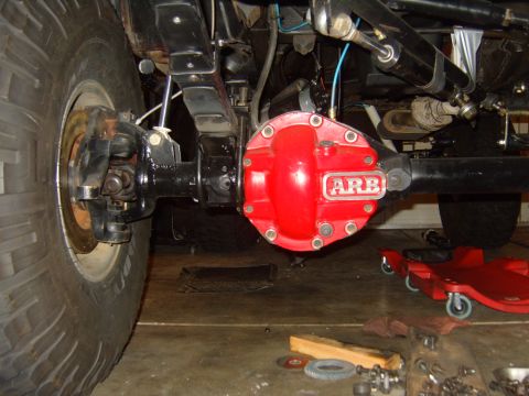 1985 Jeep CJ7 - The rear axle assembly of a Jeep features a bright red ARB differential cover and a large off-road tire.