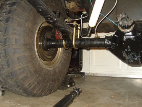 1985 Jeep CJ7 - The rear axle assembly of a Jeep is shown, with a large tire and suspension components.