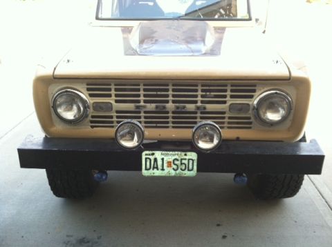 1976 Ford Bronco - Front view of a tan 1976 Ford Bronco, equipped with a black bumper and additional lighting.