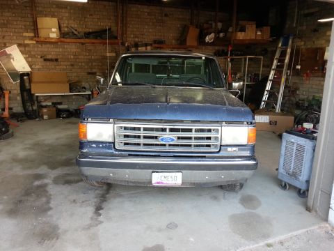1989 Ford F-150 - This 1989 Ford F-150 is seen from the front, parked indoors in what appears to be a workshop or garage.