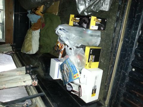 1989 Ford F-150 - The truck bed is filled with various items, including boxes of brake parts and blankets, obscuring the vehicle itself.