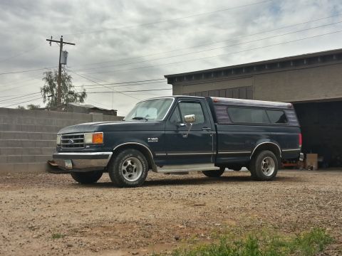 1989 Ford F-150 - This 1989 Ford F-150 pickup truck is seen from the side, equipped with a camper shell.