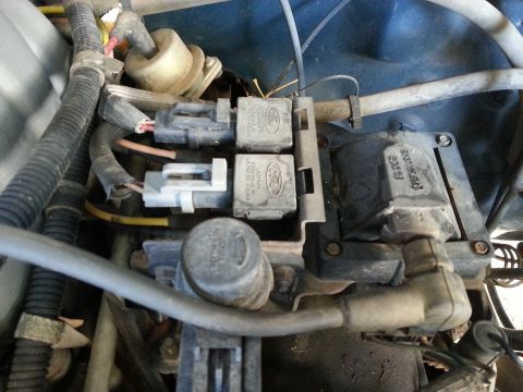 1989 Ford F-150 - Close-up view of Ford ignition coil and relays within the engine compartment.
