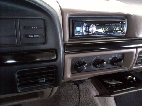 1994 Ford Bronco - The dashboard of a 1994 Ford Bronco features an aftermarket stereo and climate controls.