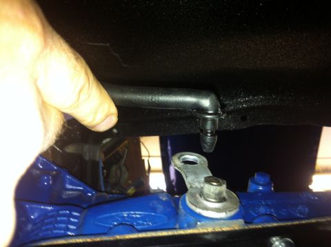 1982 Ford Bronco - A close-up shot of a vehicle's undercarriage, focusing on a hose and bracket assembly.
