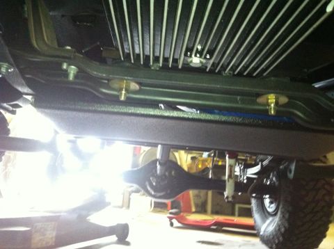1982 Ford Bronco - The photo shows the undercarriage of a vehicle, focusing on the rear axle and suspension system.