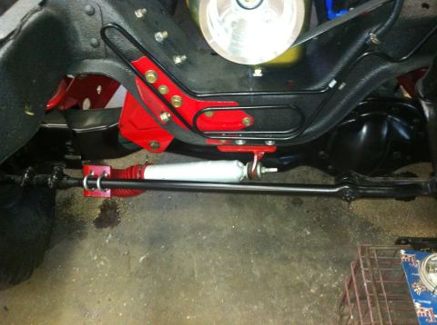 1982 Ford Bronco - Undercarriage view shows steering linkage and suspension parts, with a prominent silver shock absorber.