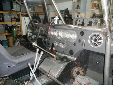 1961 International Scout 800 - Interior view of a custom vehicle, a dashboard with multiple gauges and a roll cage structure.