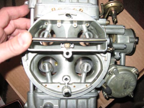 1981 Ford Bronco - A hand is shown adjusting the linkage on a Holley 80555 carburetor, a key component for engine performance.
